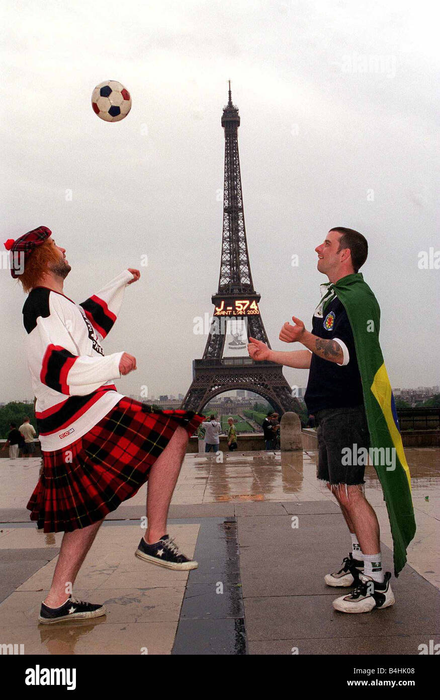 World Cup France June 1998 Football Scotland fans Richey Kenna & George Smith in Paris playing with ball in rain at Eiffel Tower Stock Photo