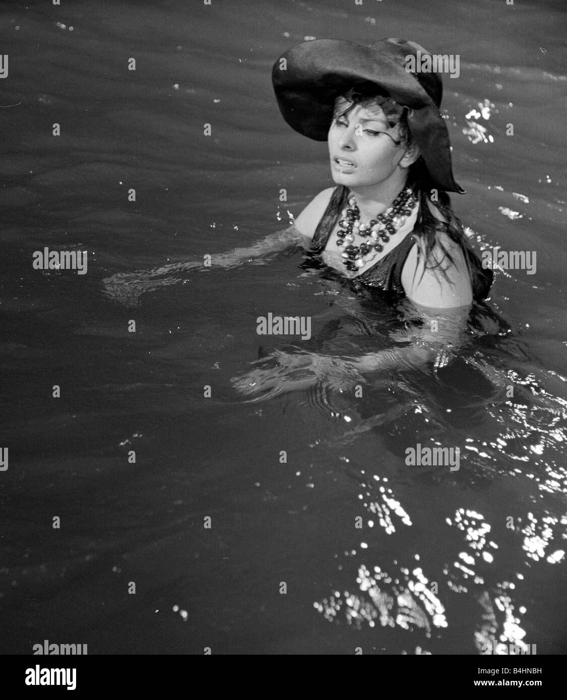 The making of The Millionairess Film July 1960 Pictured Sophia Loren Italian Actress in water during filming Plot Summary When her father dies Epifania Parerga an Italian in London becomes the world s richest woman She feels incomplete without a husband and falls in love with a humble Indian physician Dr Ahmed el Kabir Peter Sellers Stock Photo