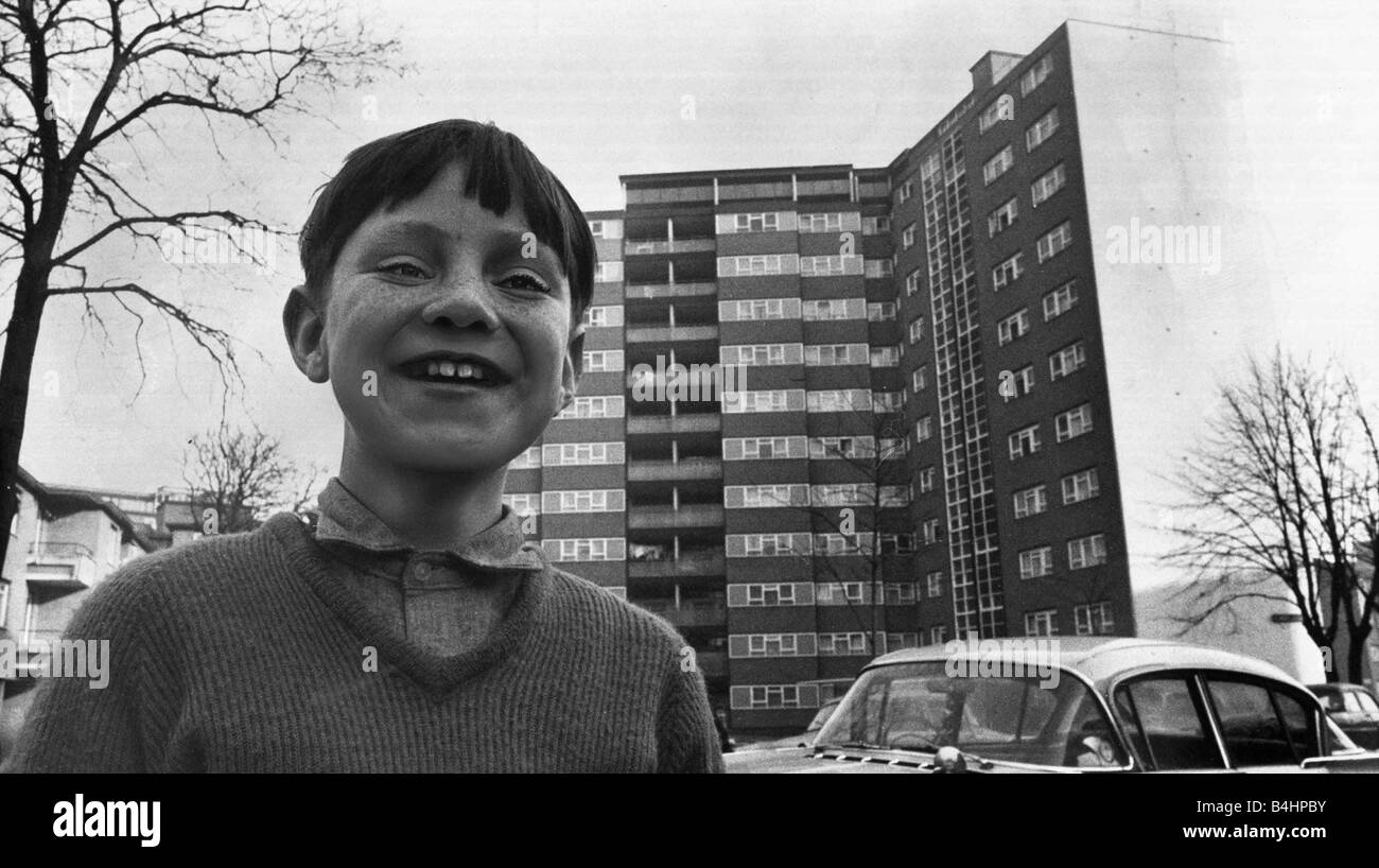 A small boy plays outside a block of flats in Stockwell South London Image used for Battery Children Stock Photo