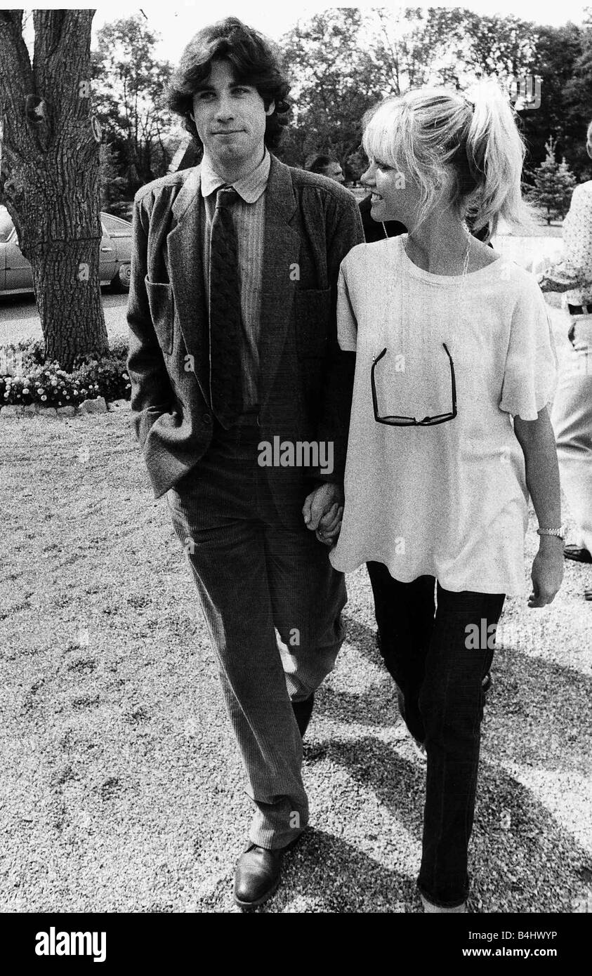 American actor John Travolta 1978 and Australian actress singer Olivia Newton John from the film Grease walk through park holding hands Stock Photo