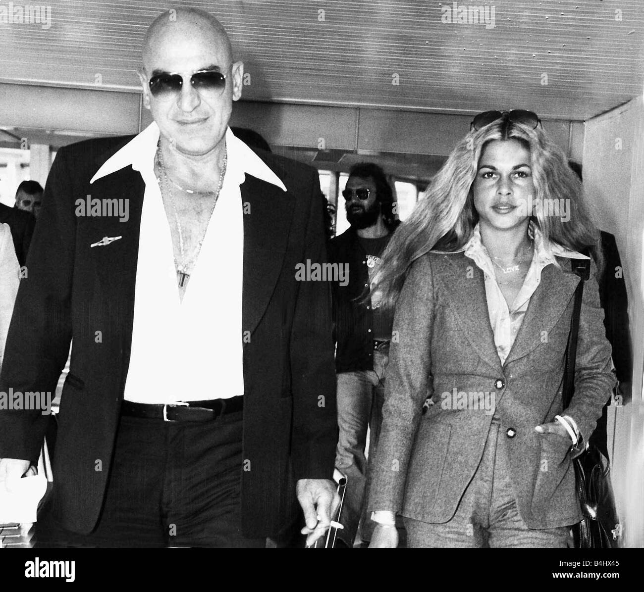 Telly Savalas film actor and girlfriend Sally in airport 1976 Stock Photo