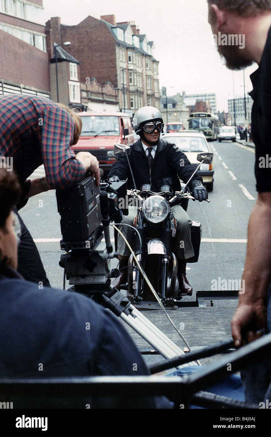 Michael Elphick actor sitting on motor bike attached rig on the back of lorry filming for his TV series Boon Stock Photo