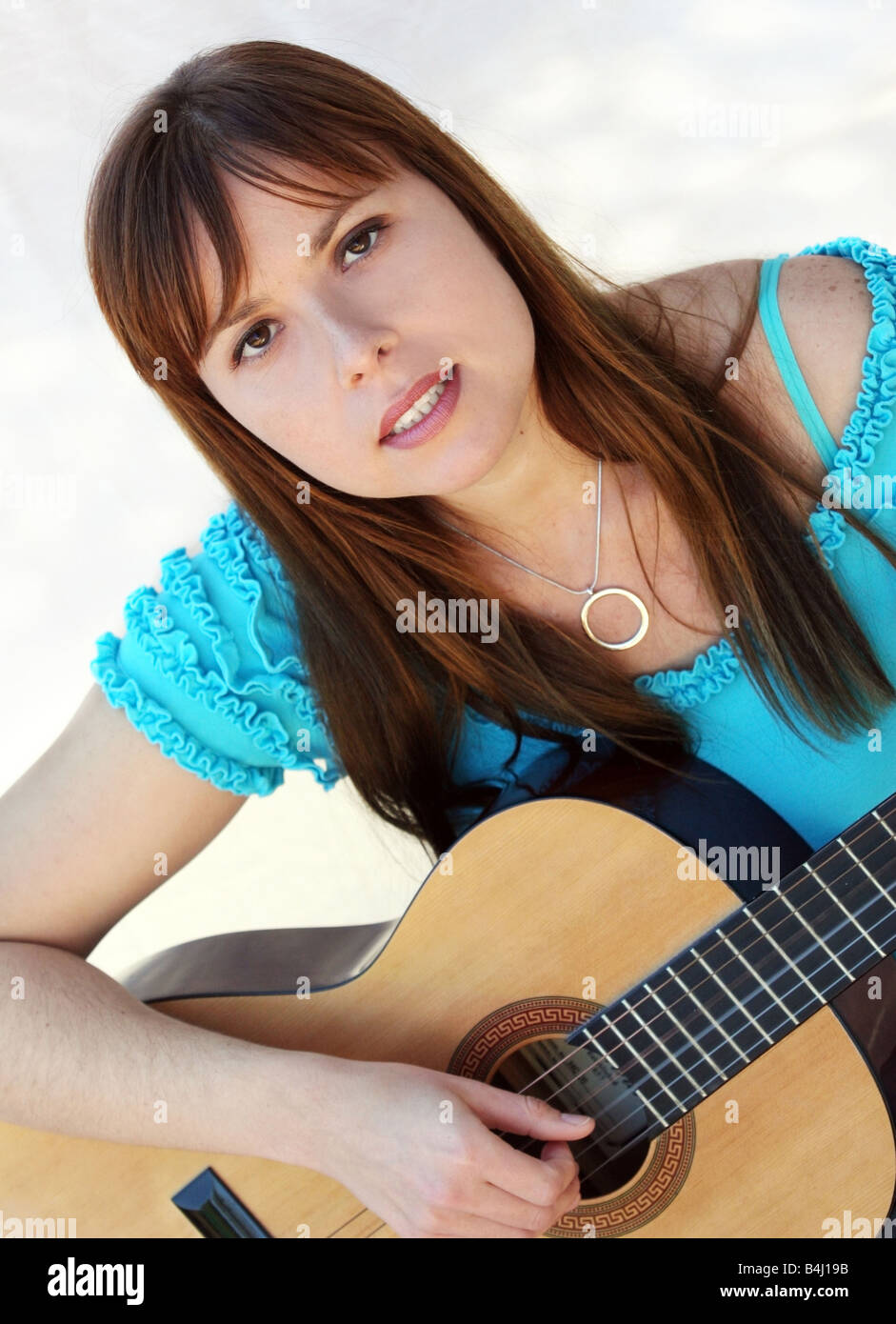 Yong pretty woman playing the guitar Stock Photo - Alamy