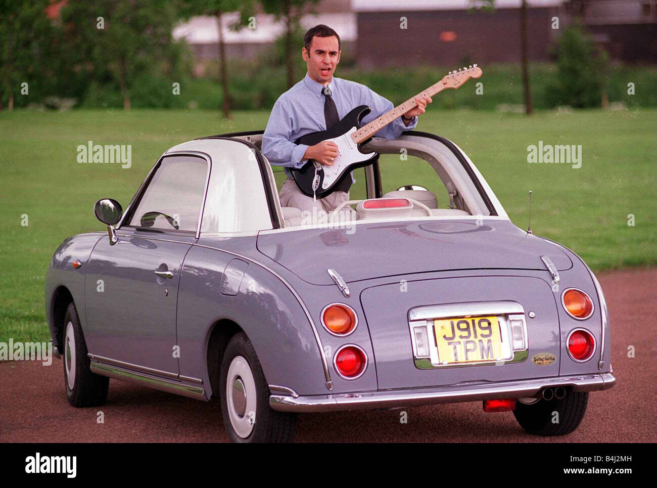 JOHN DINGWALL TEST DRIVES ERIC CLAPTONS CAR AUGUST 1997 STANDING UP ROOF  ROLLED BACK PLAYING ELECTRIC GUITAR NISSAN FIGARO Stock Photo - Alamy