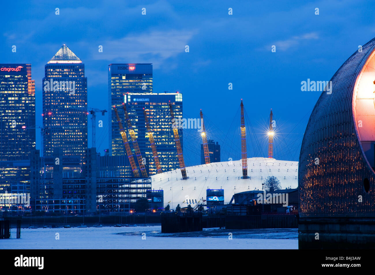 London England The O2 Arena Millenium Dome and Canary Wharf viewed from The Thames Flood Barrier at dusk Stock Photo