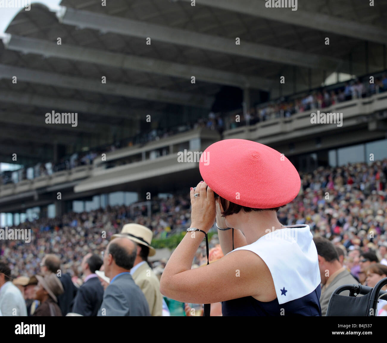 Glorious Goodwood: a bright red beret stands out in the crowd on ladies day. Stock Photo