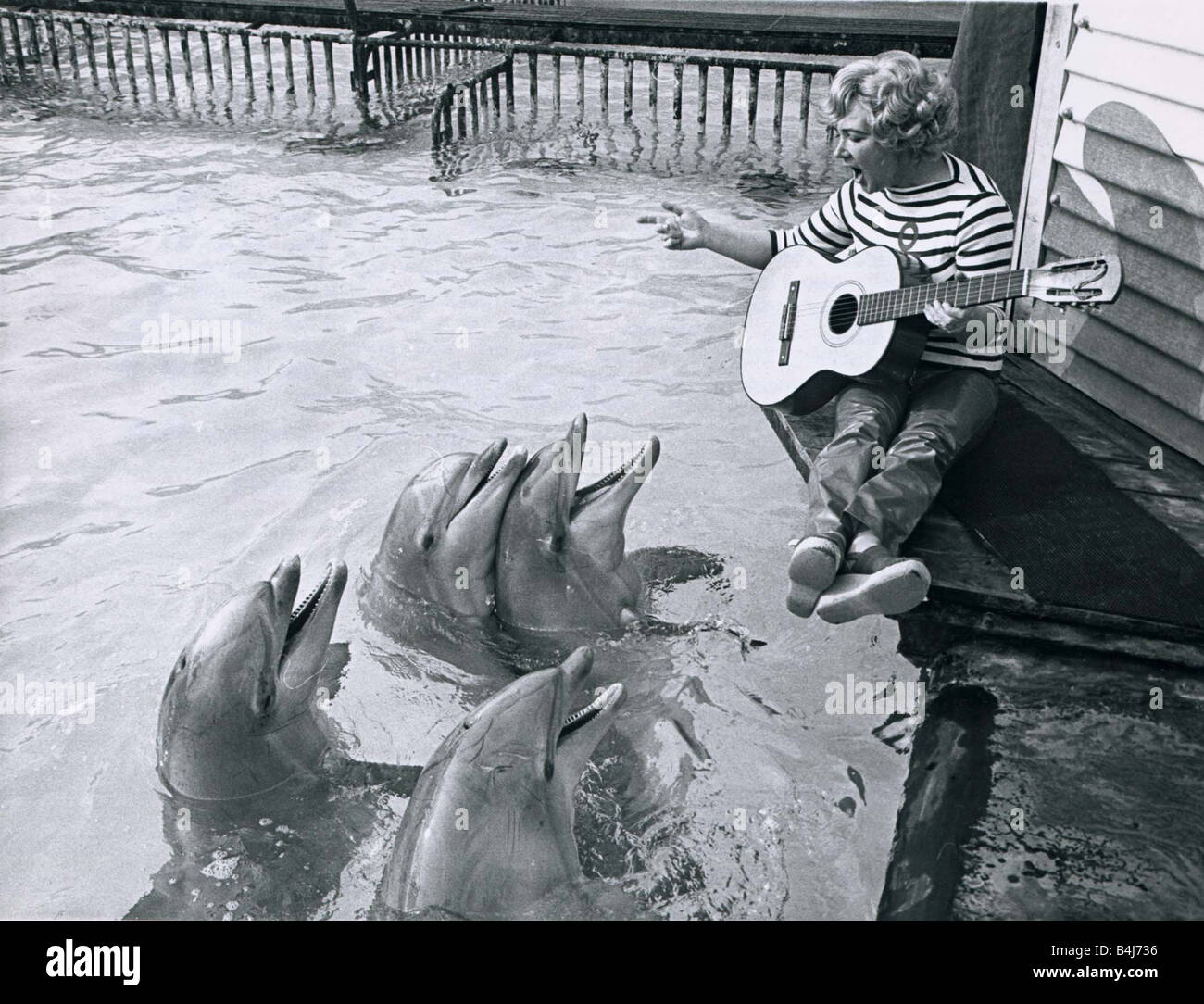 The Dolphins gather around to listen to Kay Smart as she sings and