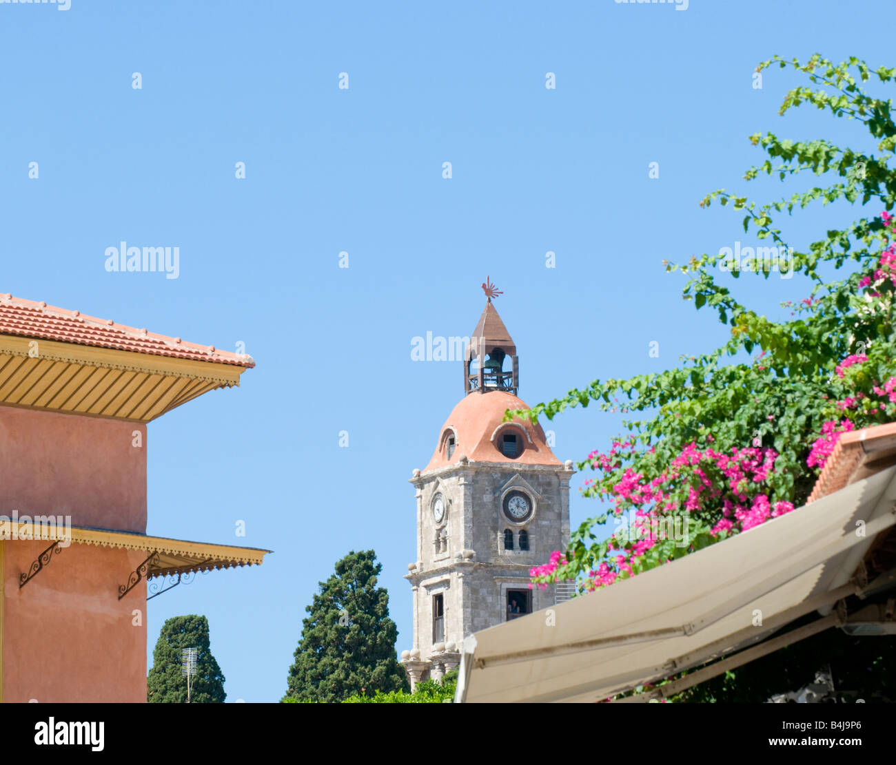 The Clock Tower in Rhodes Old Town, Greece, with Bouganvilleas Stock
