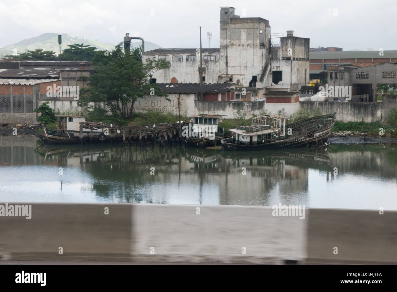 Wrecks on a river bank at a deserted factory in Rio de Janeiro, Brazil, South America. Stock Photo