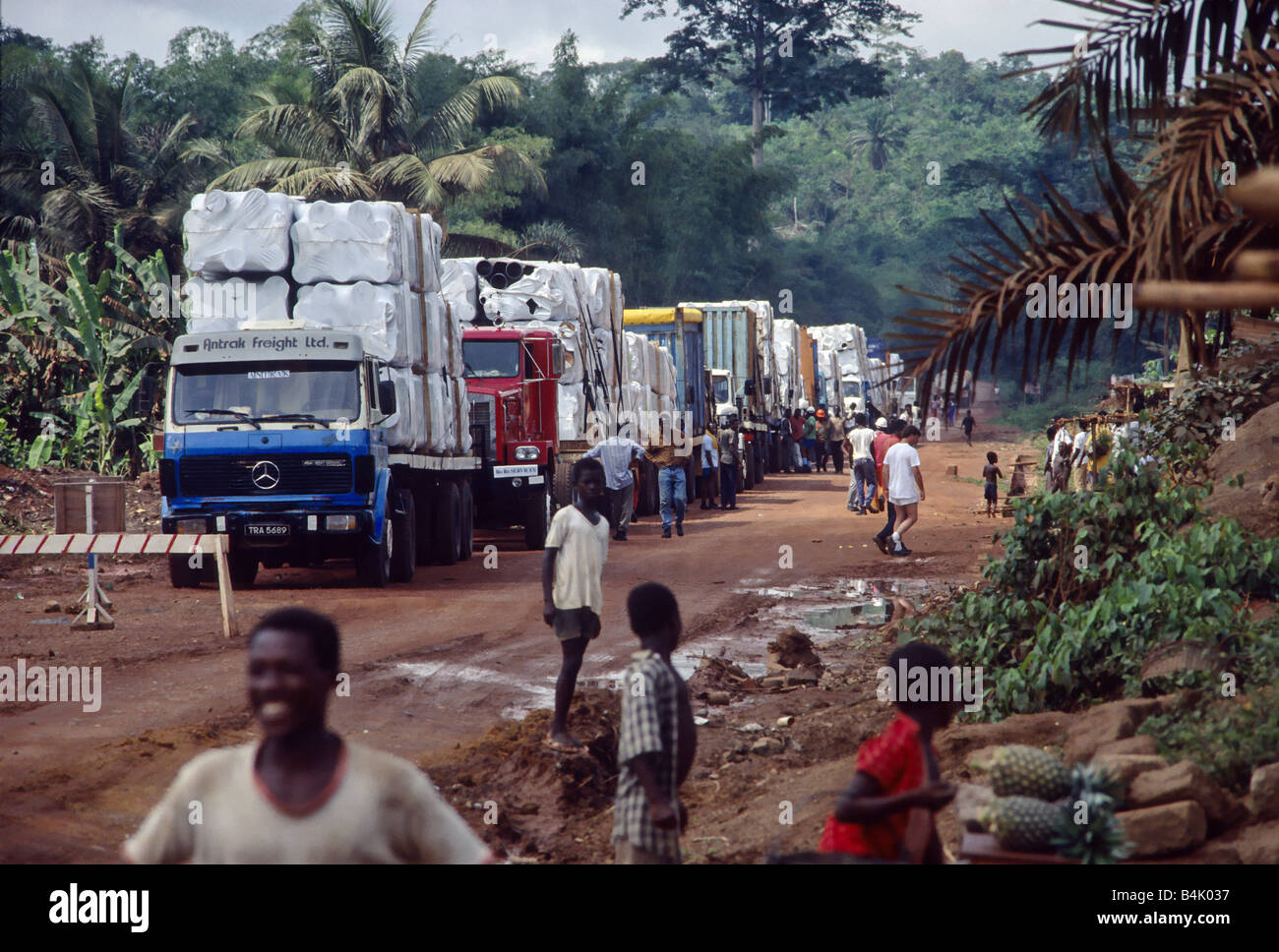 Truck Convoy with Mining Equipment on its way to the Construction Site at a Truck-Stop in the Rain Forest of Ghana, West Africa. Stock Photo