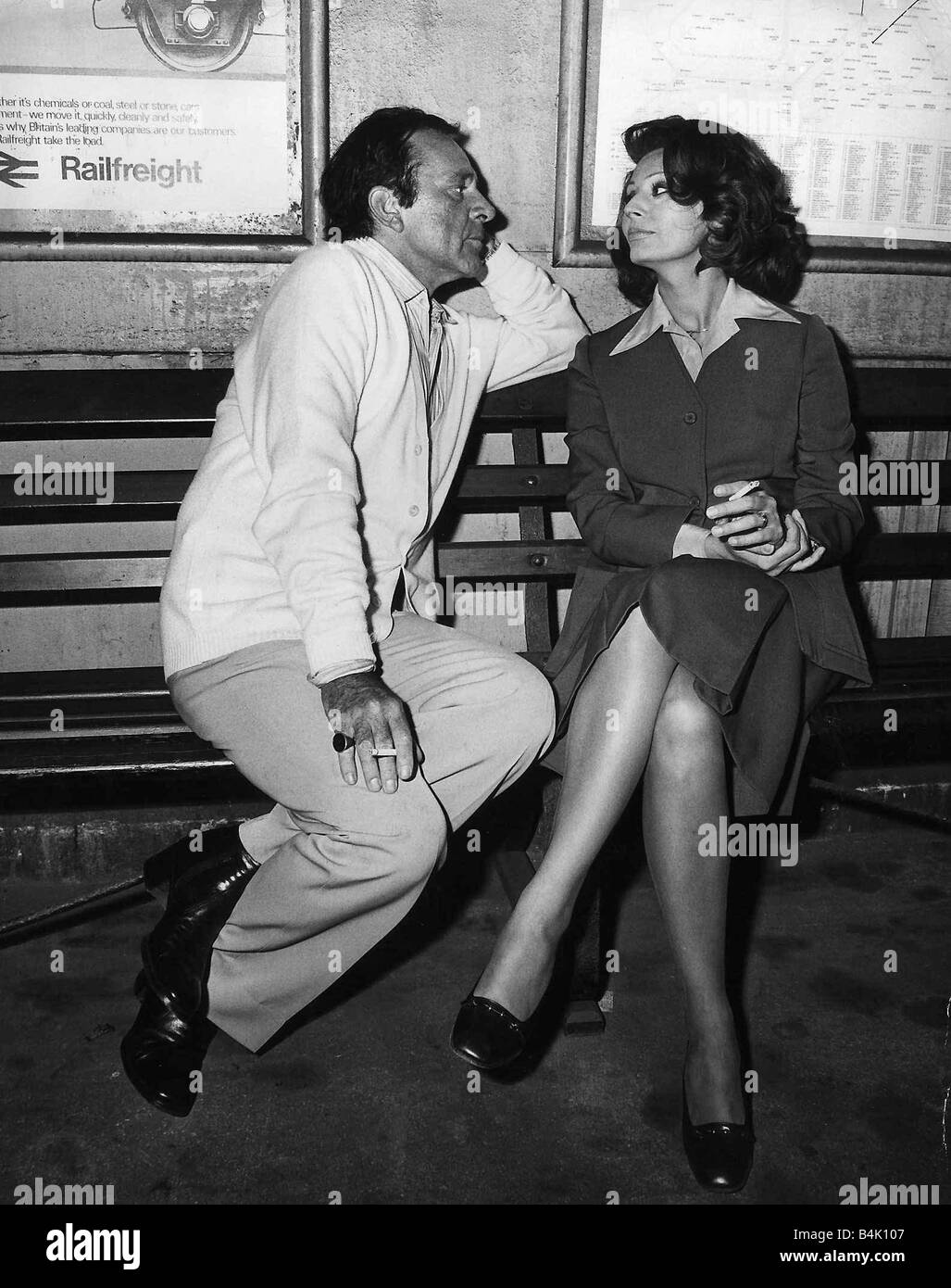 Richard Burton with Sophia Loren on a bench at a train station filming the play brief encounter July 1974 Stock Photo