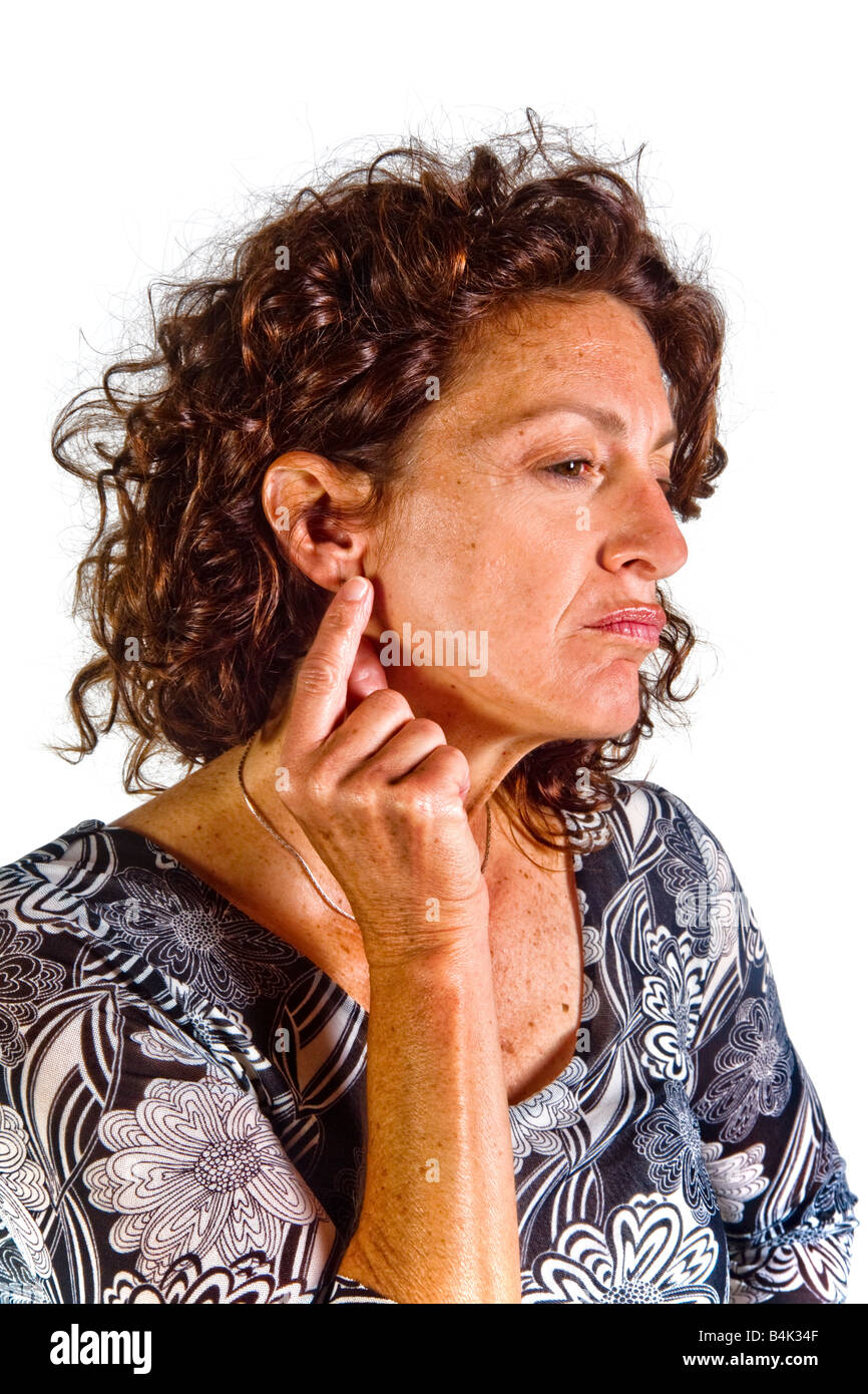 The gesture of pulling or tugging at her ear indicates an indecisive mood in this woman in nonverbal body language terms Stock Photo