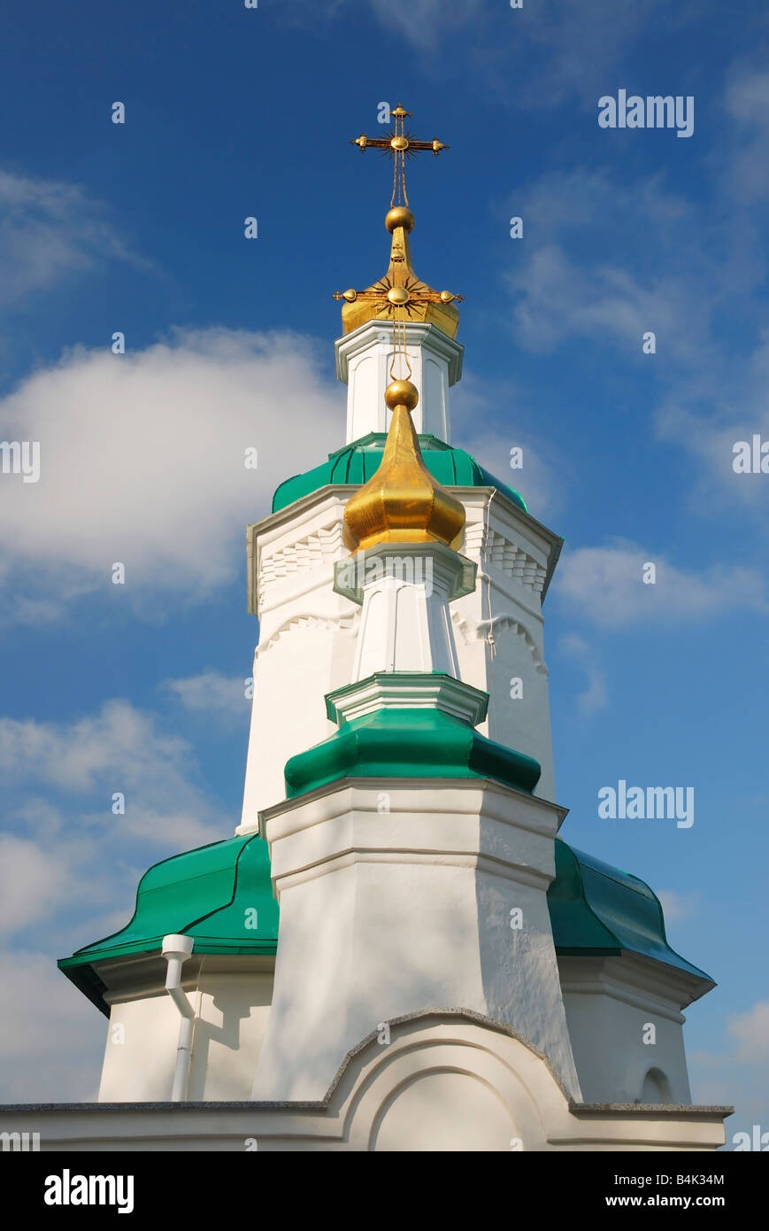 Towers of orthodox church with golden cupolas and cyan roofs against blue cloudy sky, Svyatogorskaya Svyato-Uspenskaya Lavra Stock Photo