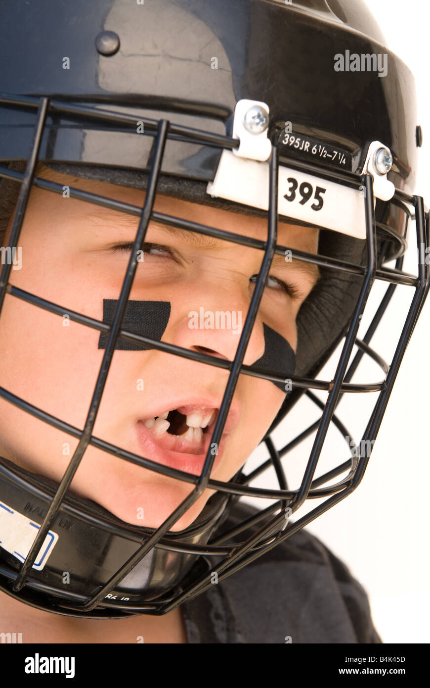 A young boy shows off his missing teeth while in his hockey gear Stock Photo
