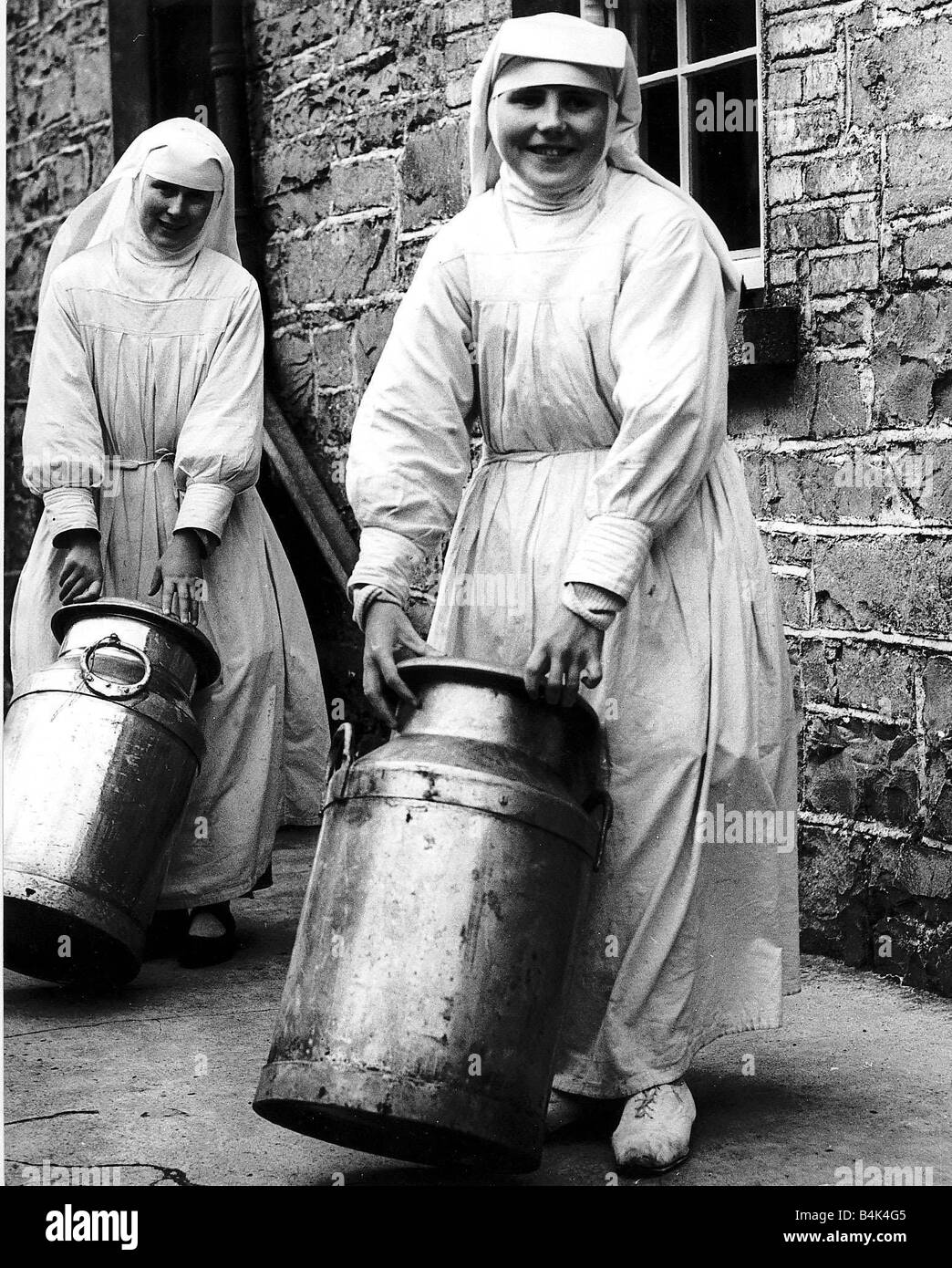 Sister Mona and Sister Benignus of Loughglynne Convent roll in the churns of milk from local farms for their cheese making 1949 Stock Photo