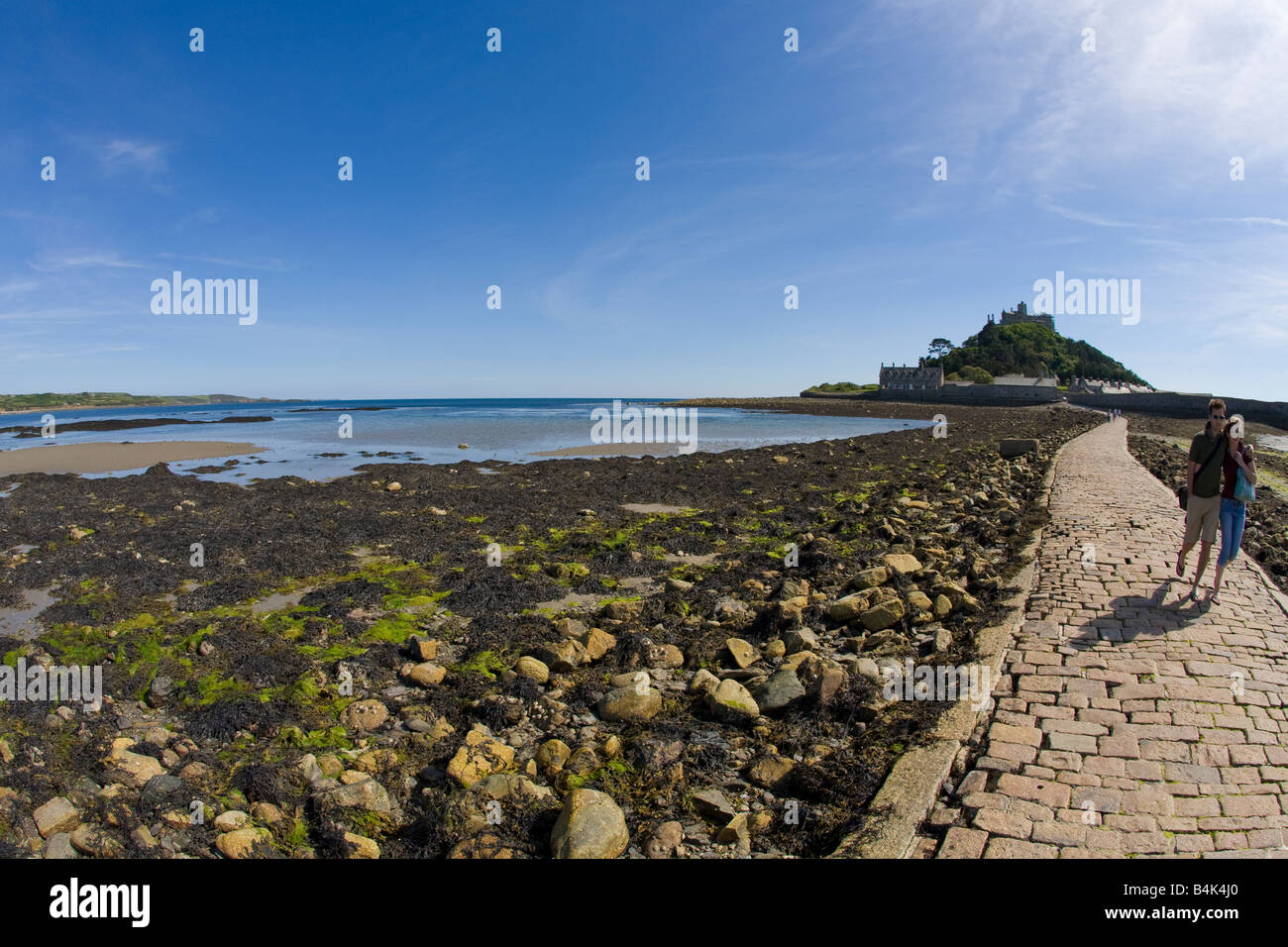 Young couple stroll along St Michaels Mount causeway in late summer sunshine Marazion Cornwall West Country England UK GB Stock Photo