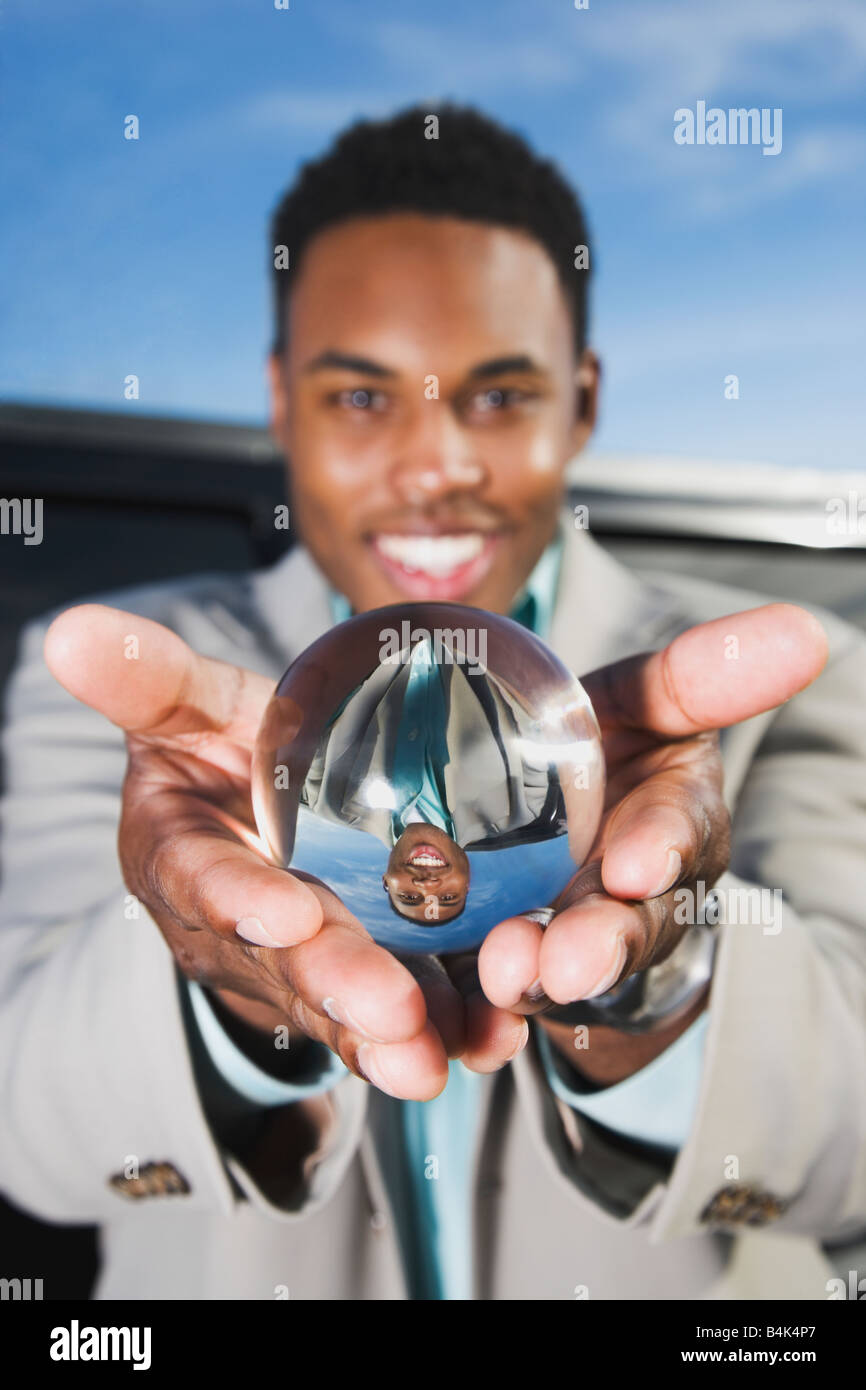 African businessman holding crystal ball Stock Photo - Alamy