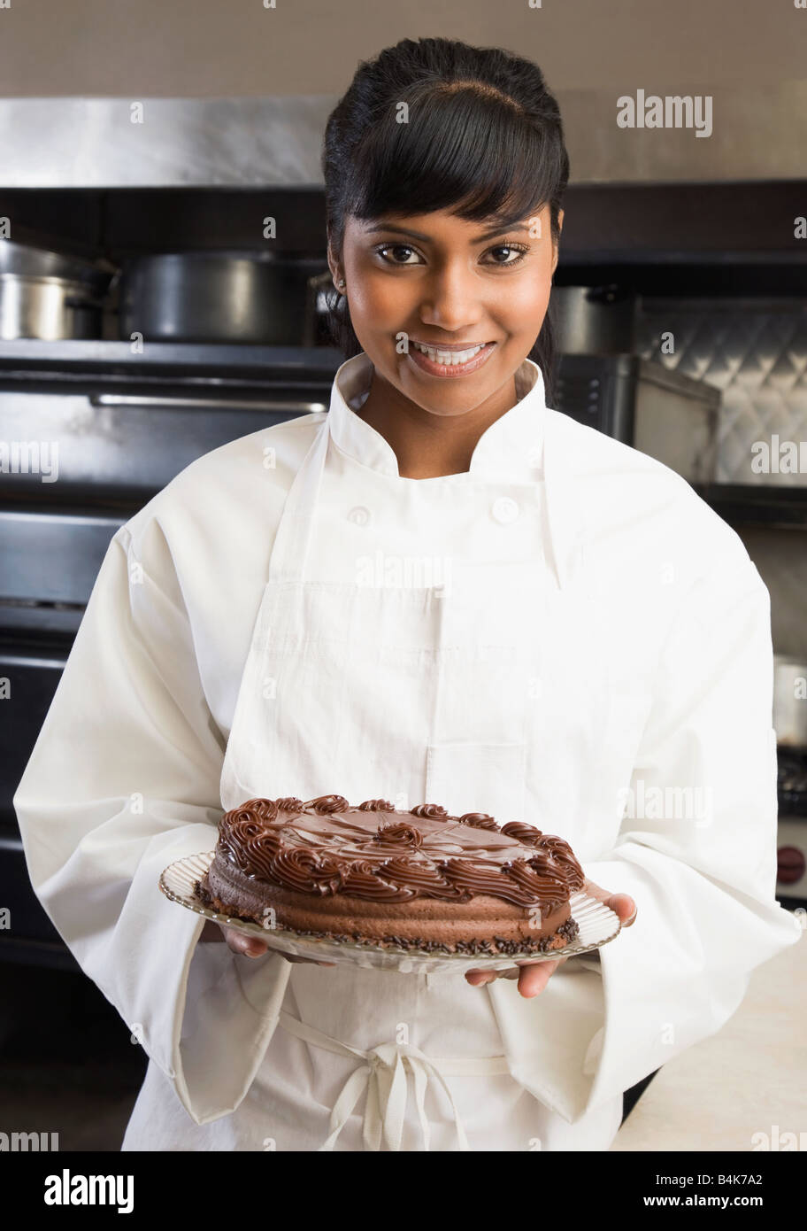 https://c8.alamy.com/comp/B4K7A2/mixed-race-female-pastry-chef-holding-cake-B4K7A2.jpg