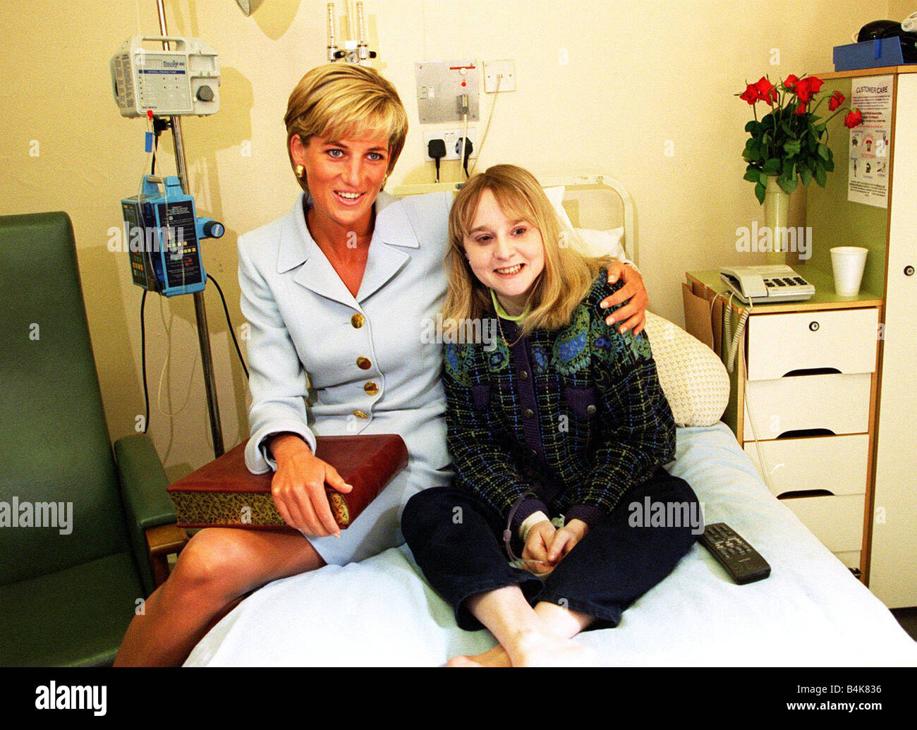 Princess Diana at Brompton Hospital where she was there to highlight the fact that it was cystic fibrosis week She looked tanned as she had just returned from a holiday in Barbuda she is pictured wearing a powder blue Versace suit stting on the bed with cystic fibrosis sufferer Nicky Welsh April 1997 Stock Photo