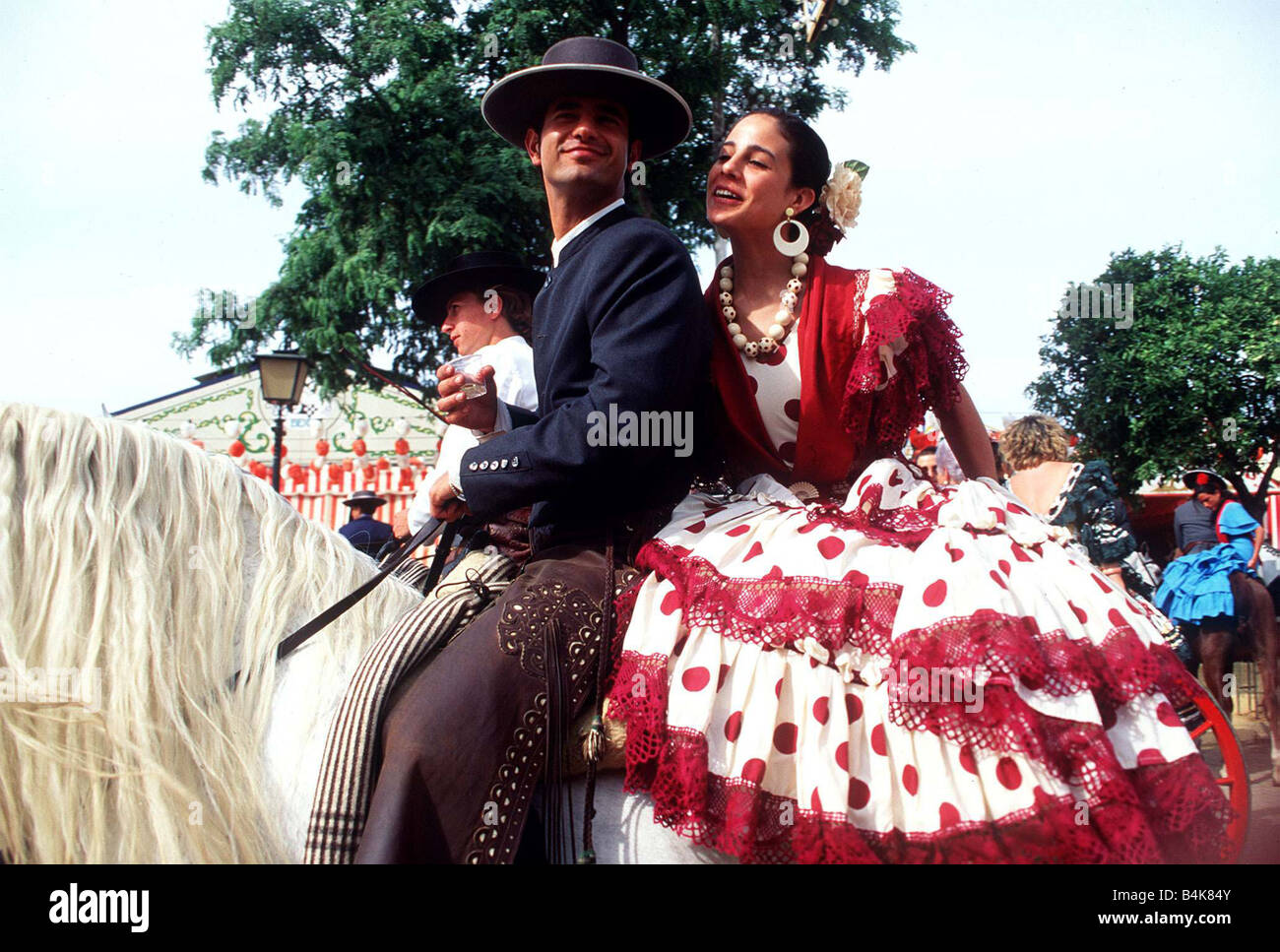 Spain Seville Feria de Abril Spanish man and woman on horse back wearing red and white flamenco dress circa 1999 Stock Photo Alamy