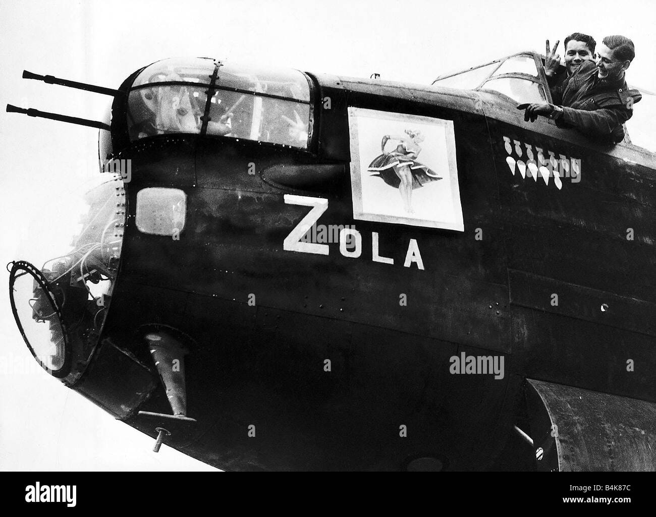 Crew of an RAF Avro Lancaster bomber point to nose art on their plane WW2 1942 Stock Photo