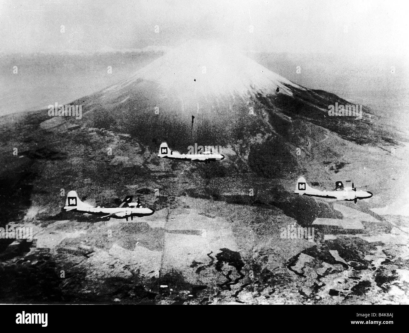 Three Boeing B29 Superfortresses of the US Air Force fly past Mt Fujiyama in attack formation during a strike against Japan in WW2 1945 Stock Photo