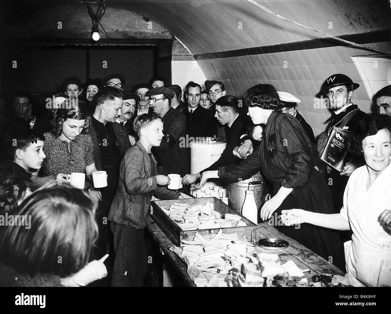 Womens Voluntary Service serve tea and sandwiches to people in an underground air raid shelter during WW2 food supply second world war world war 2 October 1940 1940s Mirrorpix Stock Photo