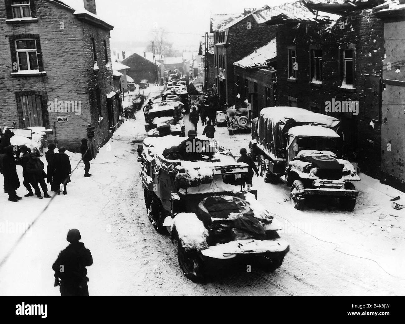 American troops pass through snow covered street in Lierheux Belgium during WW2 Stock Photo