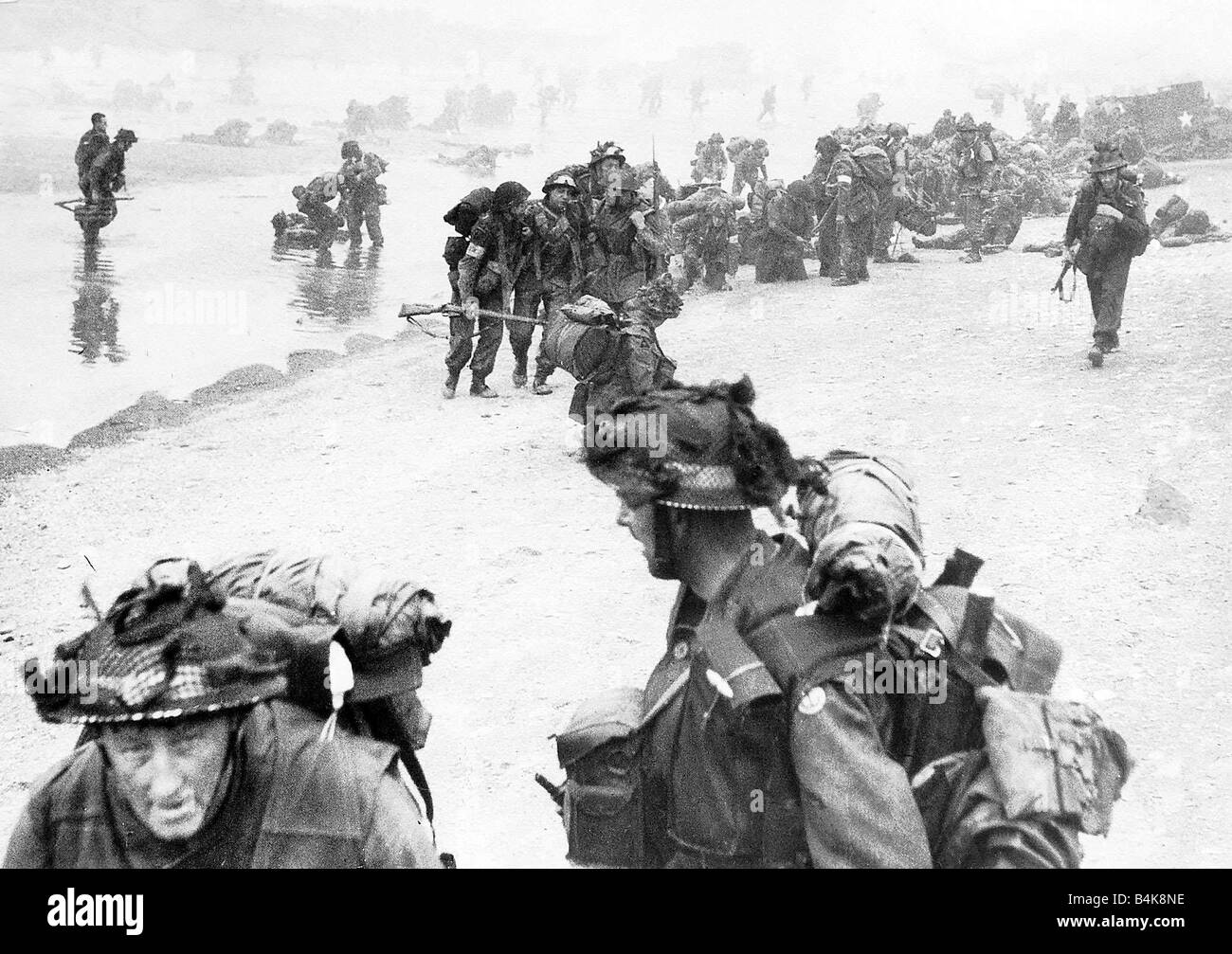 WW2 casualties from the initial assault on D Day are helped ashore on