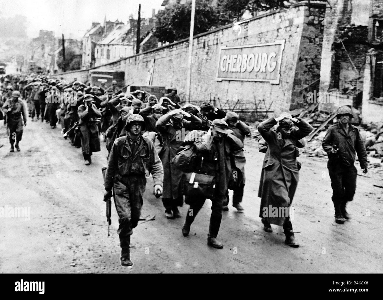 WW2 German soldiers abandoned by their officers are marched through Cherbourg after liberation by the Americans 1944 Stock Photo