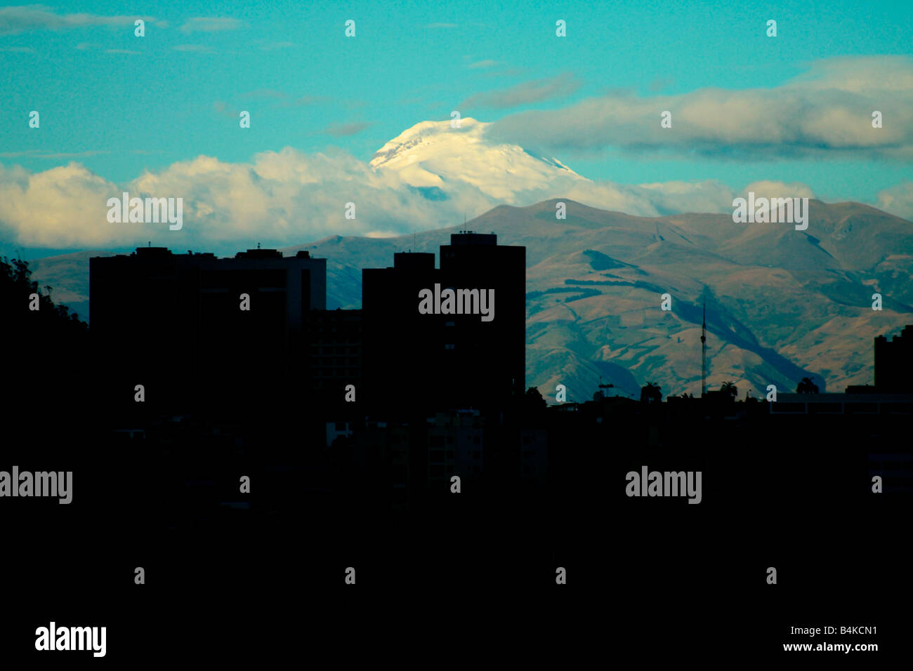 Dusk view of Cayambe volcano and silhouette of downtown Quito (new part of town), Ecuador. Stock Photo