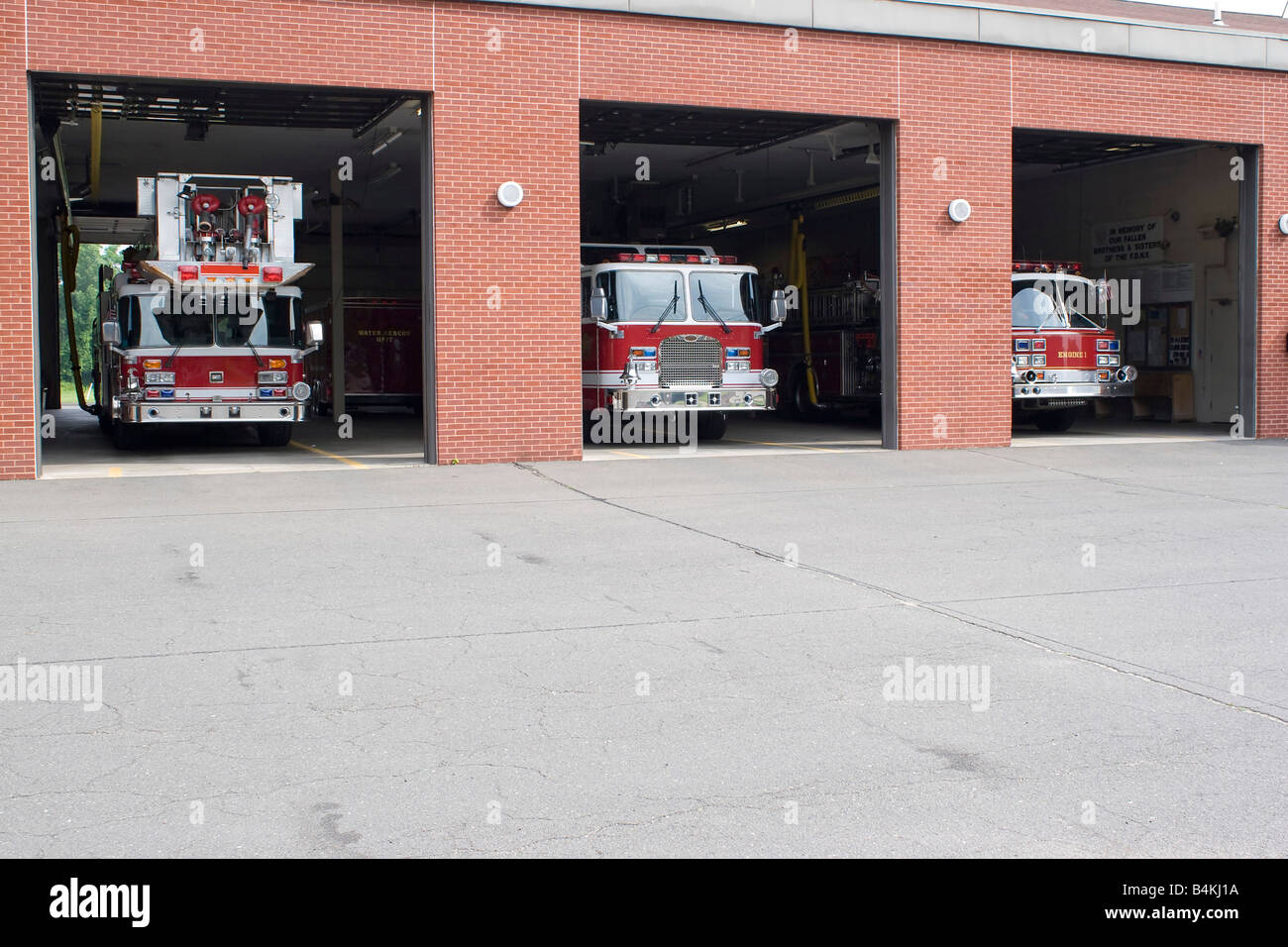 Three garage bays of fire house open with firetrucks on disply Stock Photo