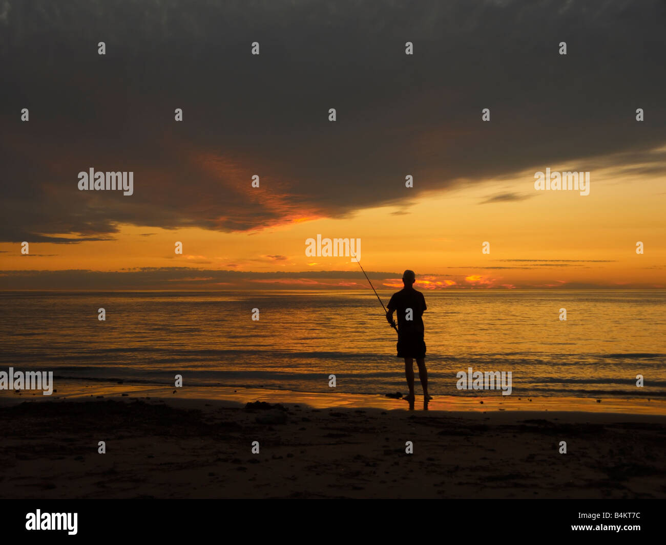 Sunset silhouette fisherman Stock Photo - Alamy