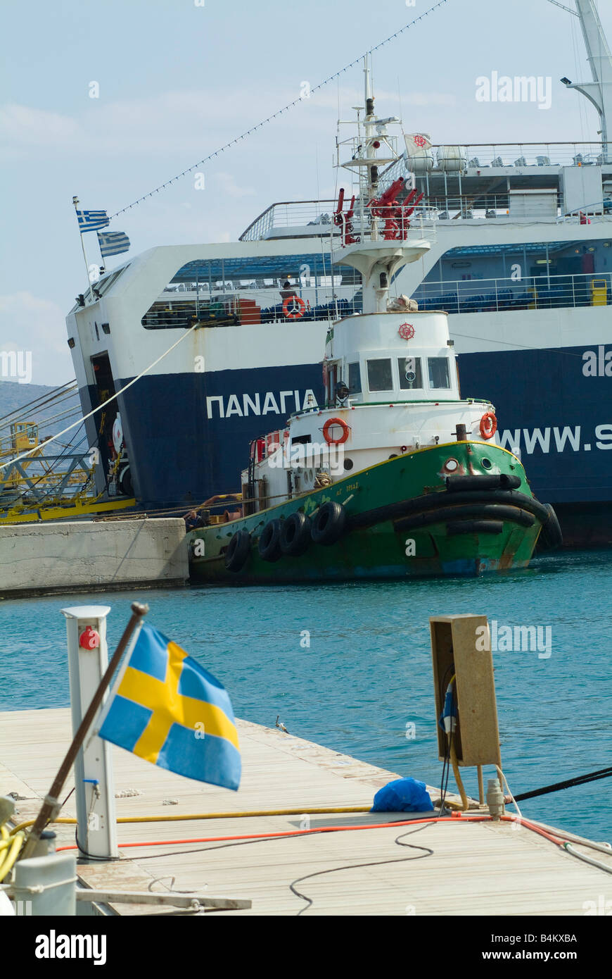 A Tugboat with Stern of a Large Greek Ferry at Lavrion Harbour in Mainland Greece Stock Photo