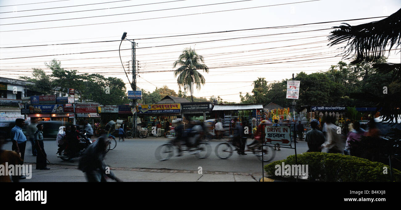 Street scene early evening Bangladesh, bicyles poeple telephone cables above heads Stock Photo