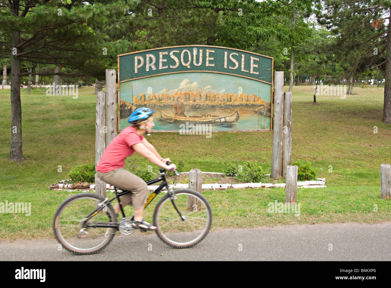 A bicyclist at the entrance to Presque Isle Park in Marquette Michigan Stock Photo