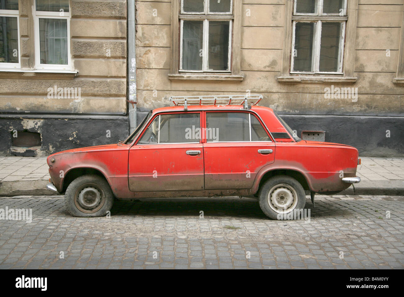 Abandoned old dirty red Lada saloon car in Lviv or Lvov, Ukraine. Stock Photo