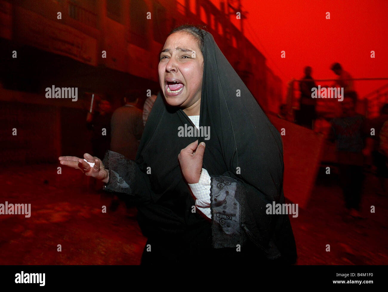 Baghdad following a massive air attack on the area of Al Shahab leaves many civilians dead Our Picture Shows A unidentified woman screaming for her husband believed dead in the blast Against the red tinted sky caused by the combination of severe dust storms and the burning oil fires around Baghdad Stock Photo