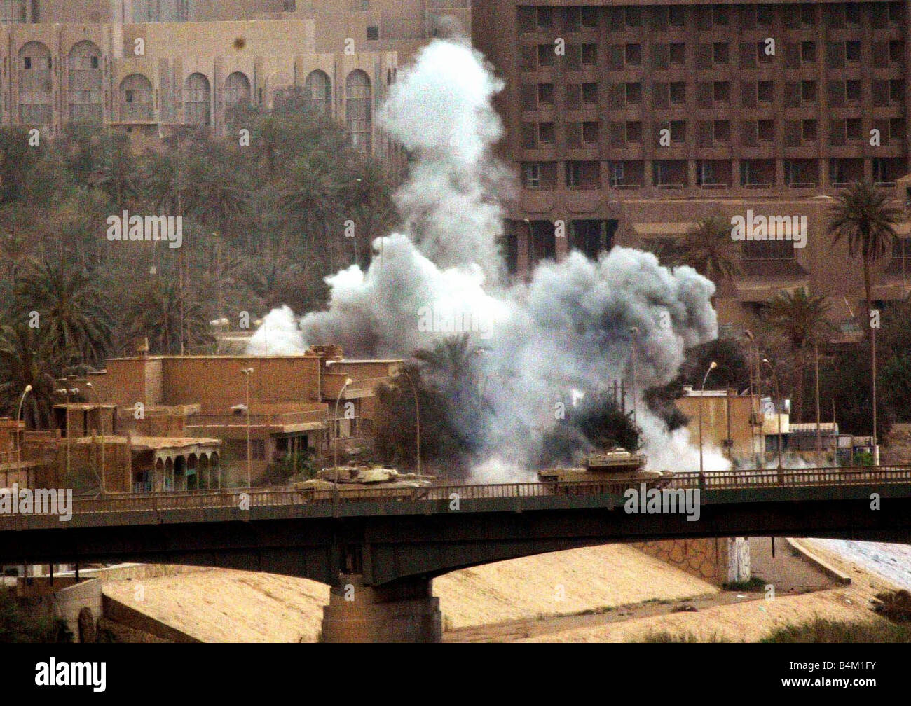 Iraq War April 2003 Americans battle at the northern end of Saddam s Presidential Estate Our picture Shows American tanks taking up a position on the The Republic Bridge as bombs land behind them Stock Photo