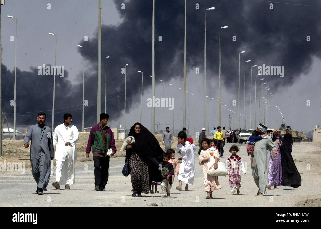 Iraq War 2003 Locals flee the burning town of Basra in Southern Iraq as armoured elements of the Royal Scots Dragoon Guards reach the out skirts of the town Stock Photo