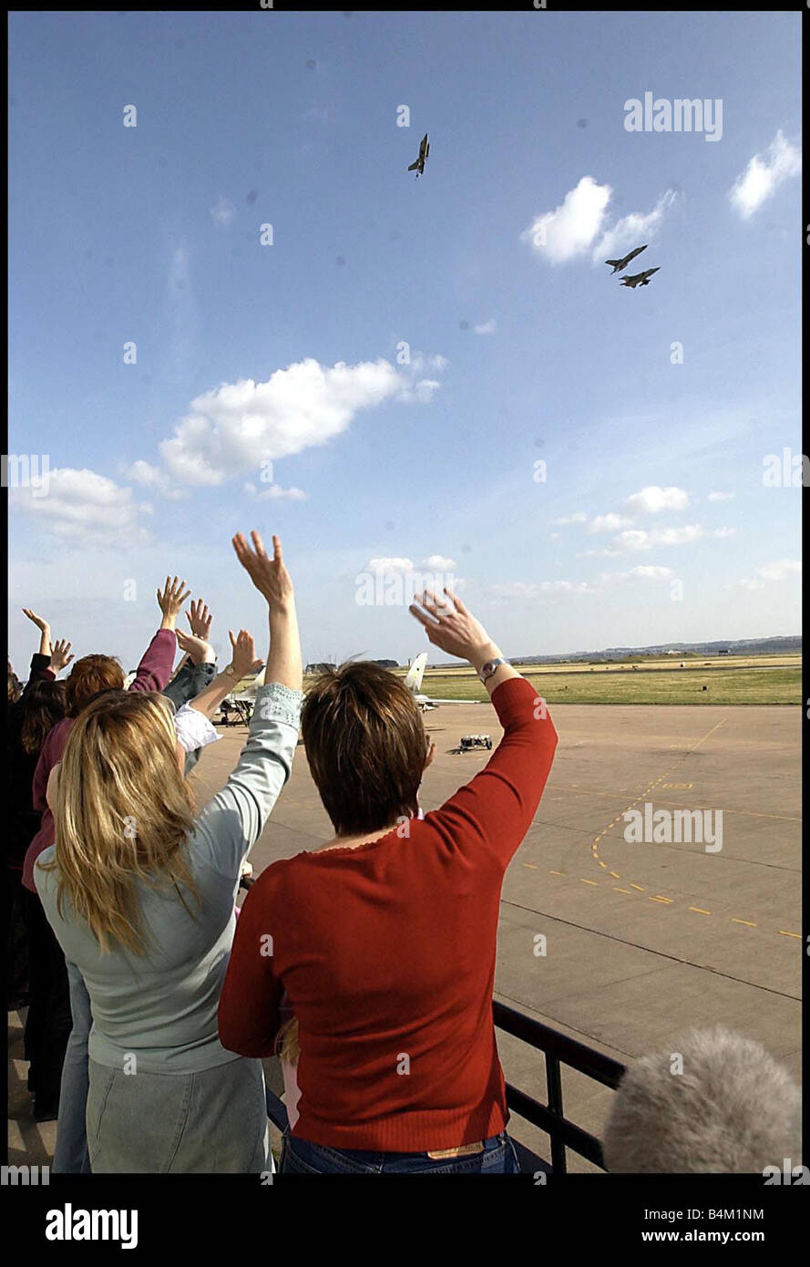 Iraq War 2003 Families wave as their husbands fathers and boyfriends perform a fly pass at RAF Leuchars on their safe arrival home from the Gulf Stock Photo