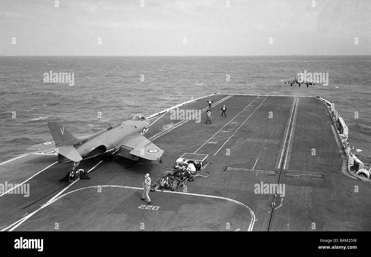 Royal Navy Aircraft Carrier HMS Victorious August 1959 A Fleet Air Arm Supermarine Scimitar aircraft waits for launch from the flight deck as another takes to the air after using the steam catapult for take off Mirrorpix Stock Photo