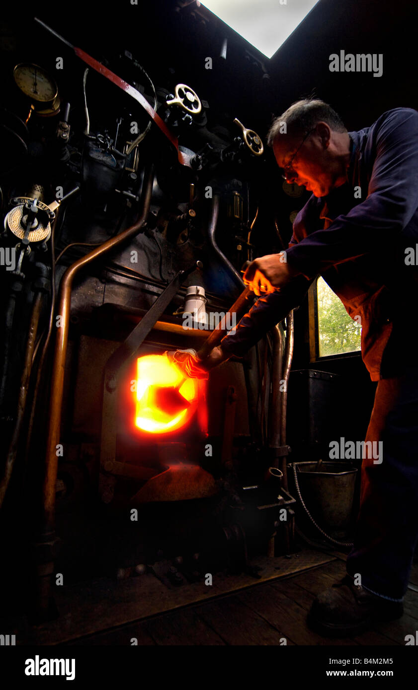 Fireman at work on the footplate of a Black Five Steam train Stock Photo