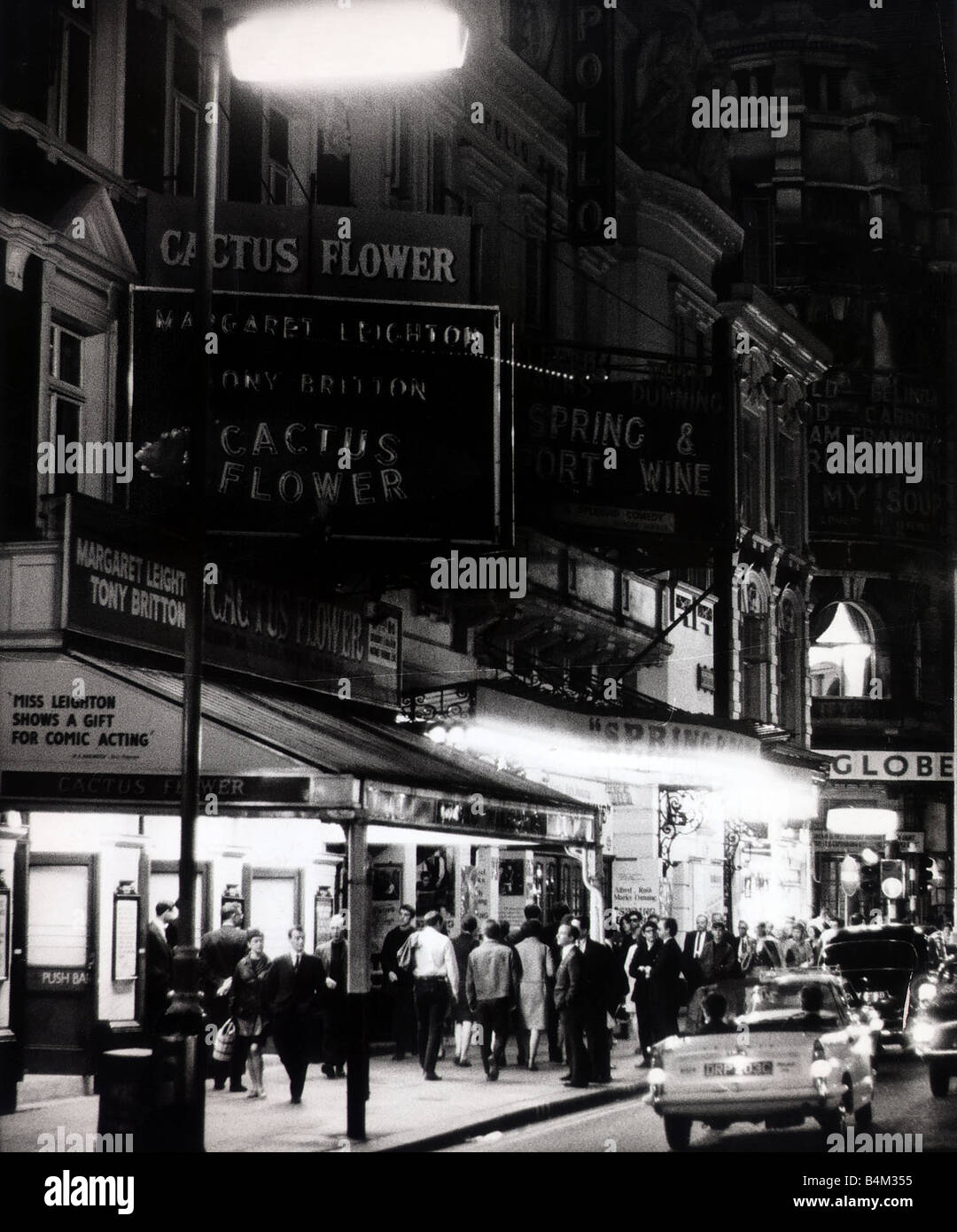 Neon lights advertise the play The Cactus Flower outside the Apollo Theatre in London Theatre goers Street Scene Sign Night Life Lighting July 1967 Mirrorpix Stock Photo