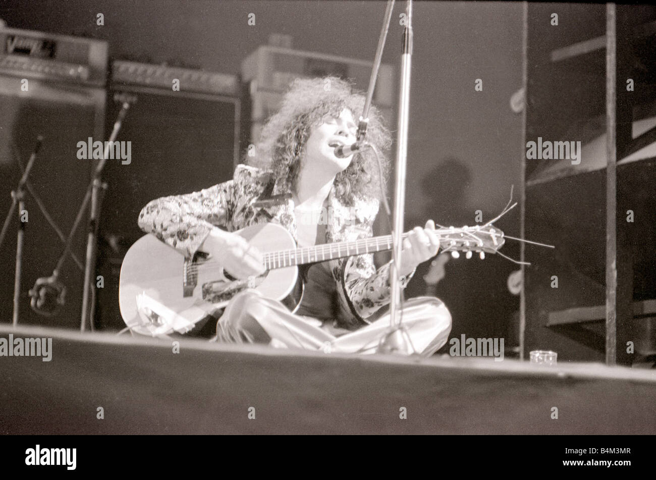Marc Bolan in concert at th Empire Pool Wembley Sitting on stage cross legged playing the guitar and singing into the microphone eyes closed Pop Concert T Rex Ringo Starr was present at the gig 72 3455 18 03 1972 1970s Marsh Mirrorpix Stock Photo