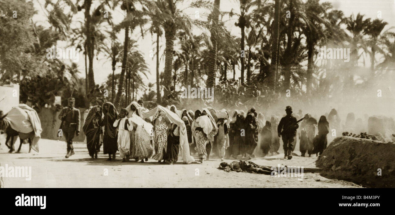 Turco Italian War Arab women and children taken prisoner by the Italian army are forced to march pass dead bodies of their husbands and fathers on their forced march to a prison camp War Conflict War Crimes Army Soldiers Desert Libya November 1911 1910s Mirrorpix Frank Magee Stock Photo