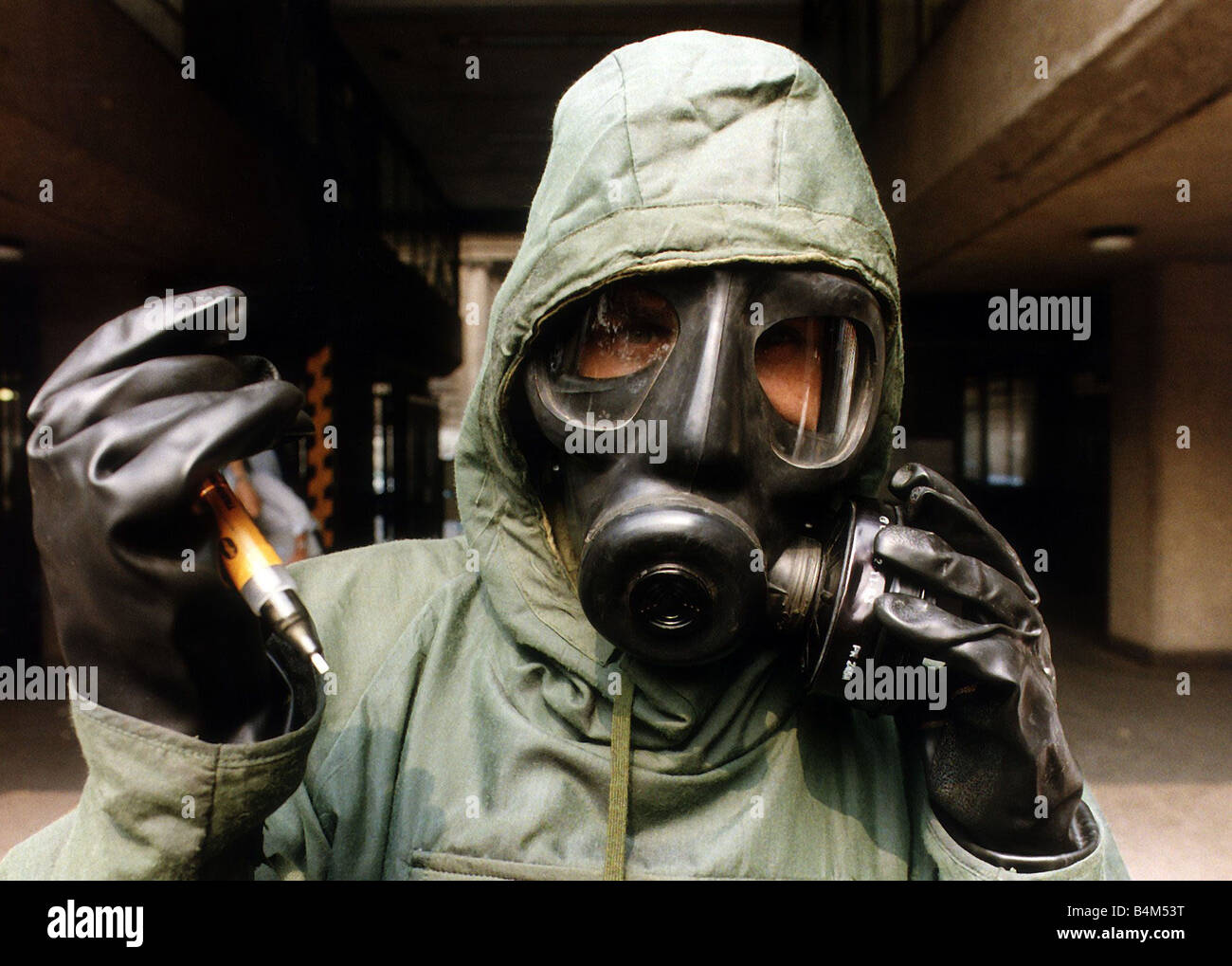 Dr Alistair Hay wearing chemical warfare suit August 1990 of the type used in the Gulf War holding syringe filled with chemical Stock Photo