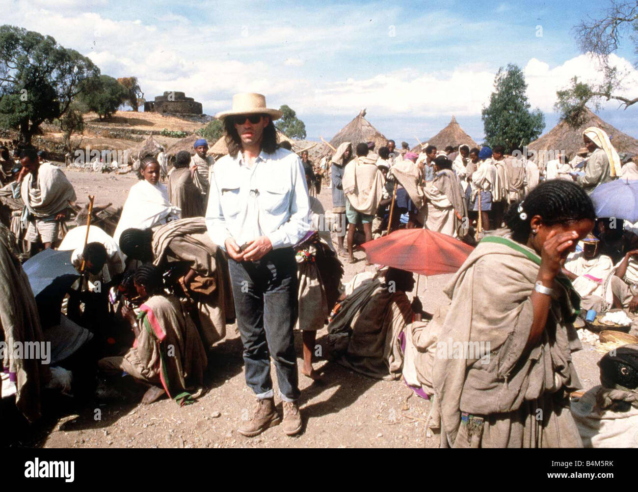 Bob Geldof in the famine area of Ethiopia wearing a hat sunglasses jeans and boots circa 1985 Mirrorpix Stock Photo