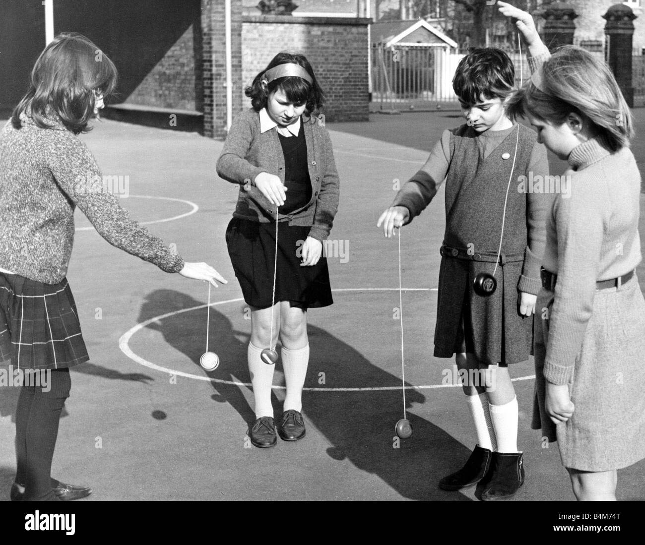 School children playing yoyo games in the school yard March 1967 Stock