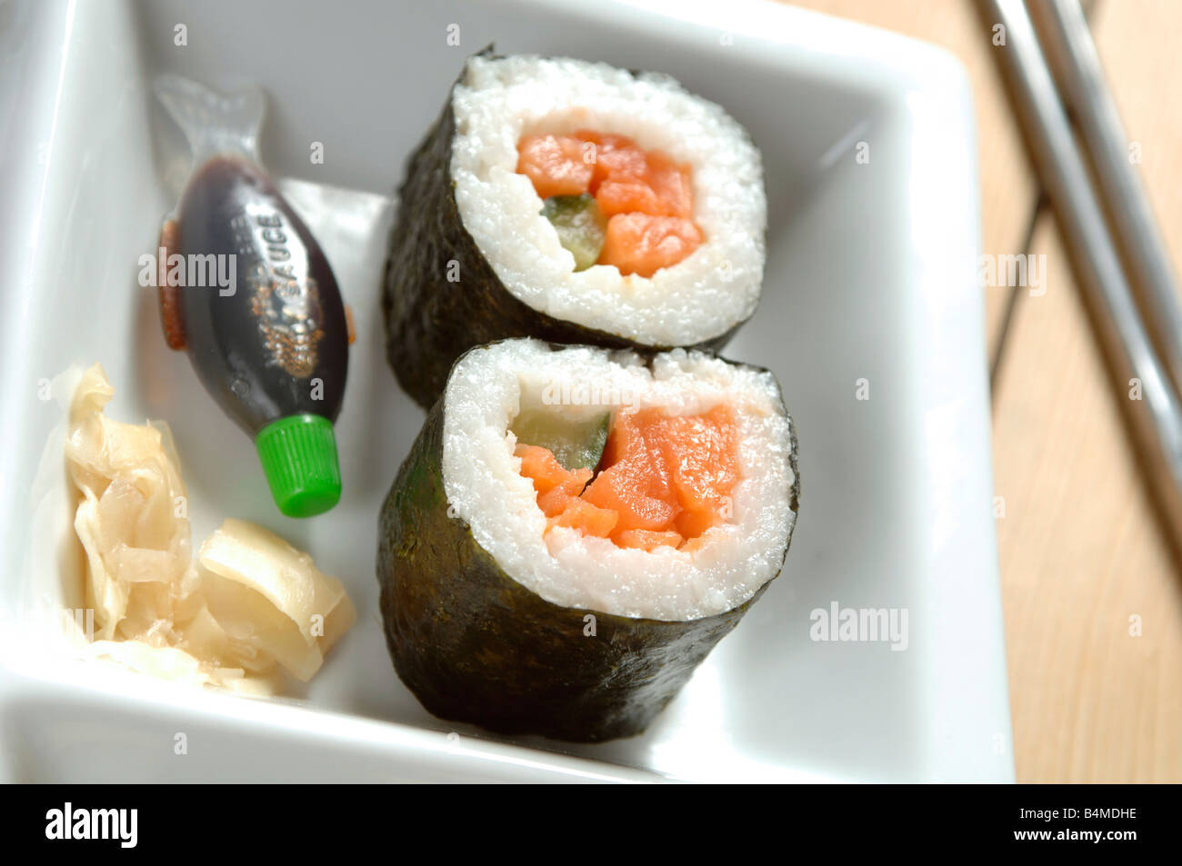 a small dish of sushi with chopsticks, vegetable or fish sushi at a restaurant or take away Stock Photo